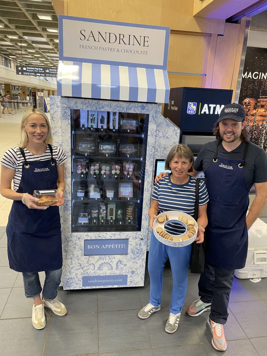 <who>Photo credit: Steve MacNaull/NowMedia Group</who>From left, Sandrine partners Elyse Wright, Sandrine Raffault and Wes Wright at the new Sandrine vending machine at Kelowna International Airport.