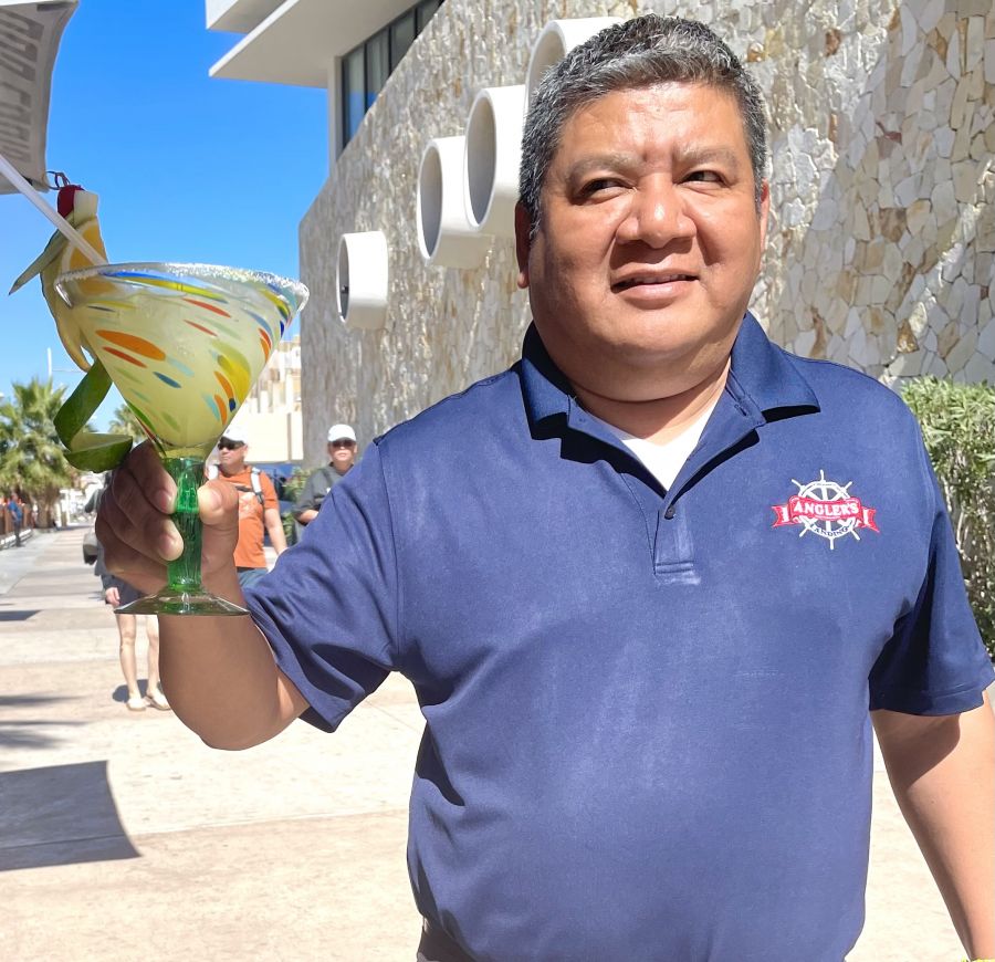 </who>Waiter Javier, above, shows off the house margarita at Angler’s Landing in Cabo San Lucas. Below, a close up of the drink in a margarita glass with a tacky cactus stem.