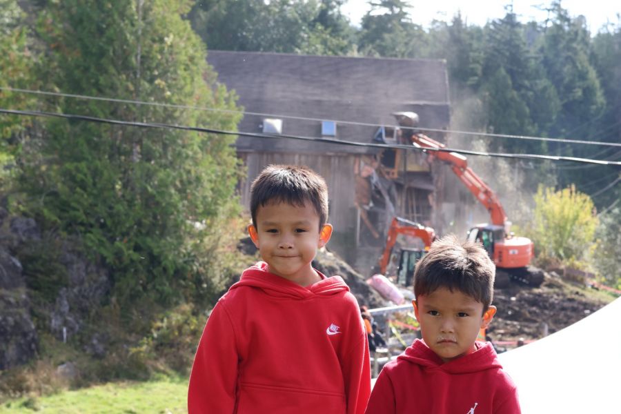 <who> Photo Credit: Nora O’Malley Local Journalism Initiative Reporter</who> Hesquiaht boys Kalanis, 6, and Maya (Niumaia), 4, witnessed the excavator tear down the bad place with mean teachers on Meares Island. The boys went to the Oct. 9 healing event in support of their grandmother Marilyn Lucas and their late grandfather Pat Charleson Jr. who both attended residential school. 