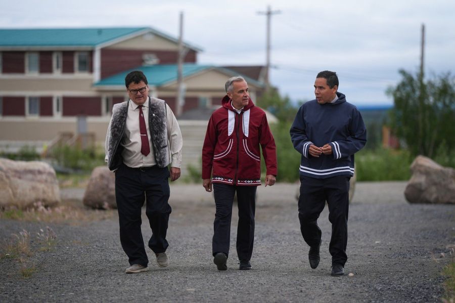 <who>Photo Credit: Canadian Press</who>Prime Minister Mark Carney walks with Duane Smith, left, chair and CEO of the Inuvialuit Regional Corporation, and Natan Obed, right, president of the Inuit Tapiriit Kanatami, to a meeting of the Inuit-Crown Partnership Committee in Inuvik, NWT, on Thursday.