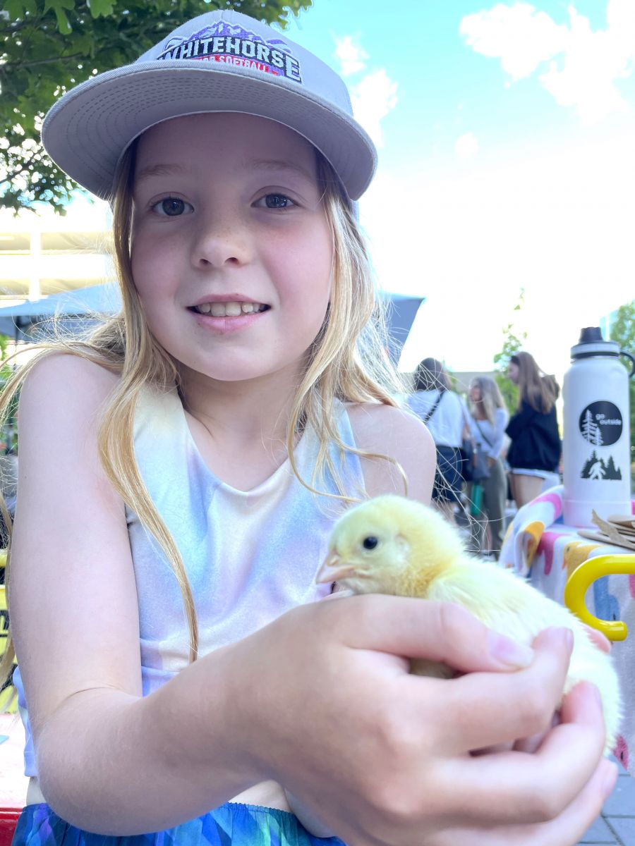 <who>Photo credit: Steve MacNaull/NowMedia Group</who>Lucia, 9, has a cuddle at the Hatch a Chick Chick Holding Station at the Kelowna Farmers' & Crafters' Market on Wednesday morning.