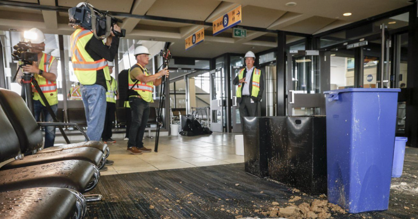 <who> Photo credit: Canadian Press </who> Chris Miles, right, chief operating officer of the Calgary International Airport, speaks to members of the media on a tour of a closed concourse after parts of the domestic terminal building suffered hail and rain damage, in Calgary Aug. 6, 2024.