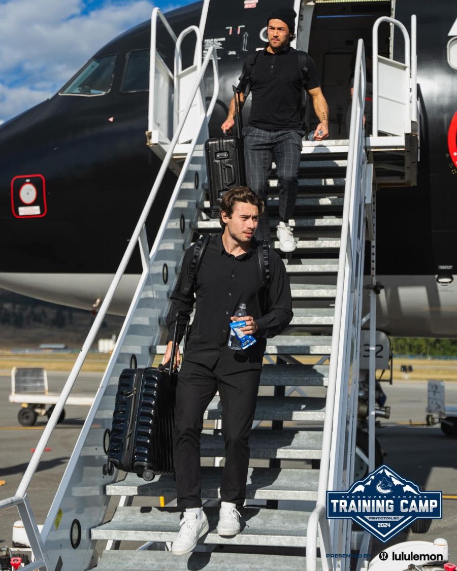 <who>Photo Credit: Vancouver Canucks/Facebook</who>Quinn Hughes and Kiefer Sherwood step onto the tarmac at Penticton Regional Airport ahead of training camp in September 2024.